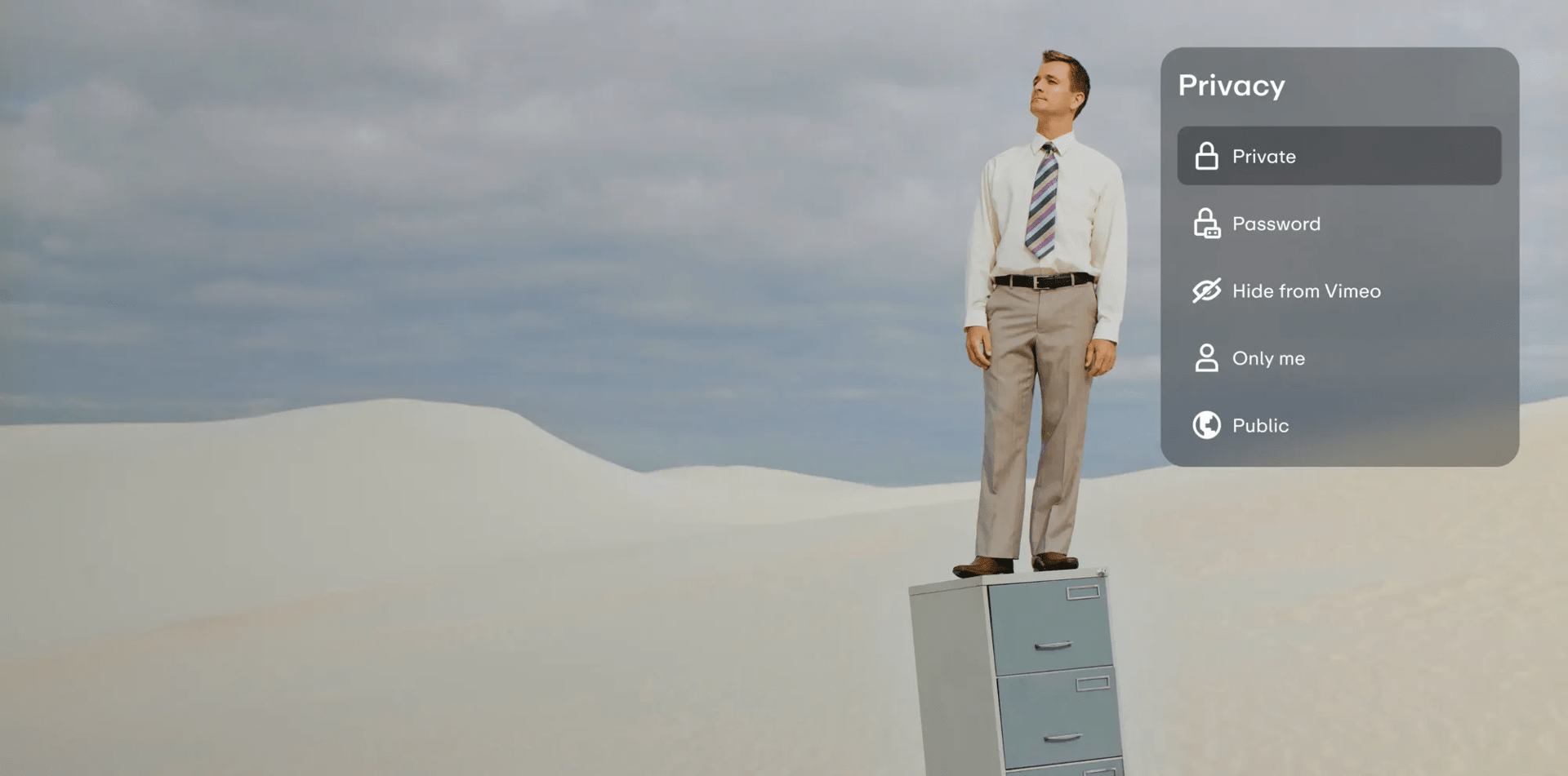 Man in business clothes stands on filing cabinet in the middle of the desert. 
