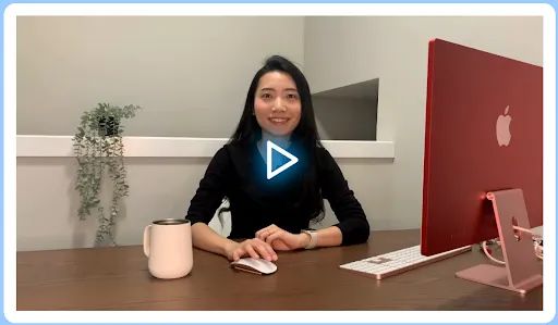 An auto-playing video featuring a real presenter smiling and looking directly at the camera.